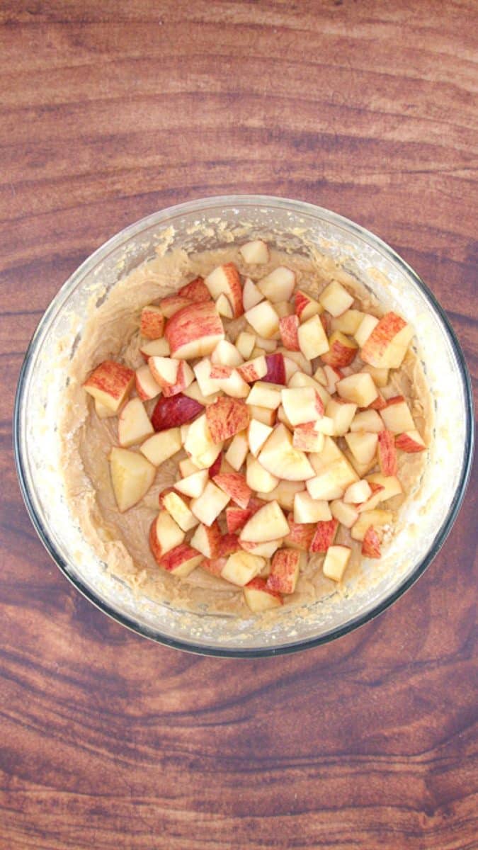 Diced apples added to a bowl of cake batter - Hostess At Heart