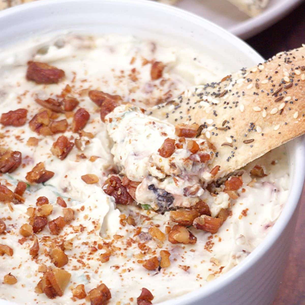 Close view of a bowl of creamy gorgonzola cheese dip topped with crunchy chopped pecans. Hostess At Heart