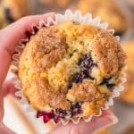 A closeup view of a hand holding a blackberry muffin - Hostess At Heart