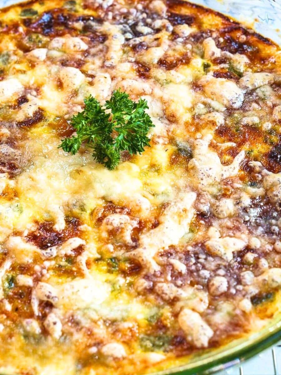 Closeup view of a pie plate filled with a baked 3 cheese asparagus crustless quiche - Hostess At Heart