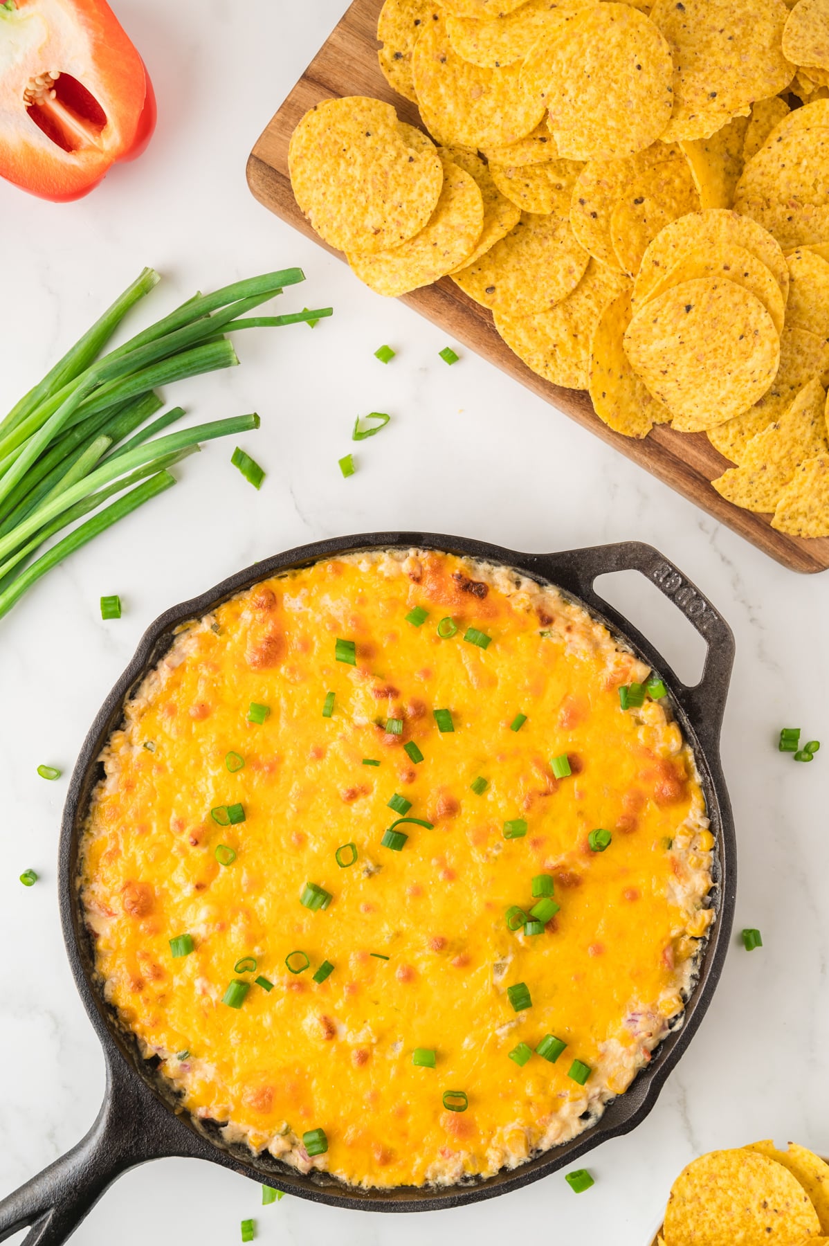 A skillet of freshly baked corn dip topped with hot cheese - Hostess At Heart