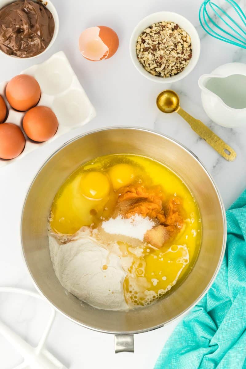 Top down view of a mixer bowl filled with pumpkin babka bread ingredients including flour, pumpkin, butter, salt, and sugar - Hostess At Heart