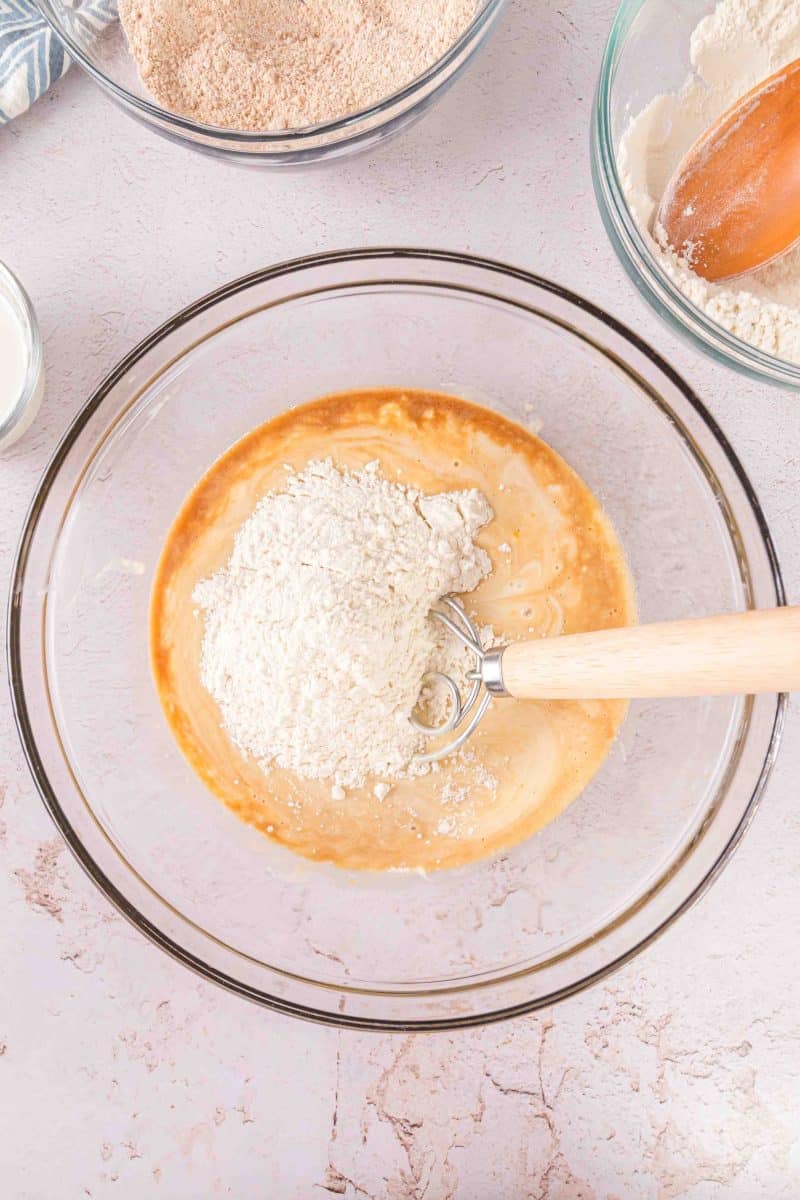 Combining the dry and wet ingredients of the sourdough coffee cake batter in a mixing bowl with a dough hook. 