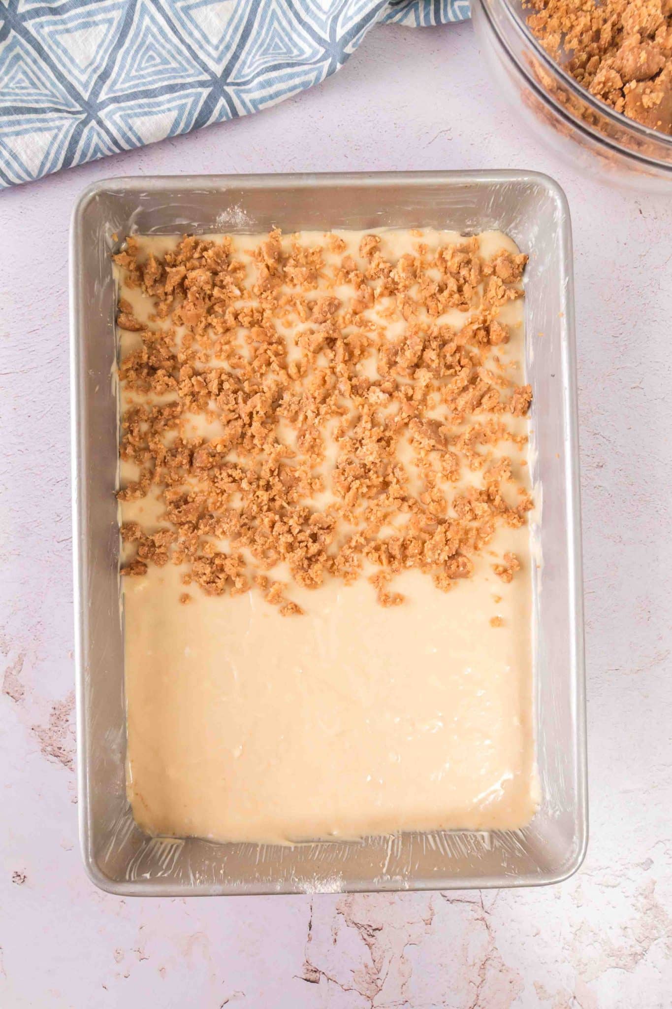 Spreading the coffee cake in the pan and topping it with the crumble.