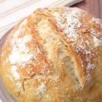 Top-down view of a scored round loaf of homemade almost no-knead bread - Hostess At Heart