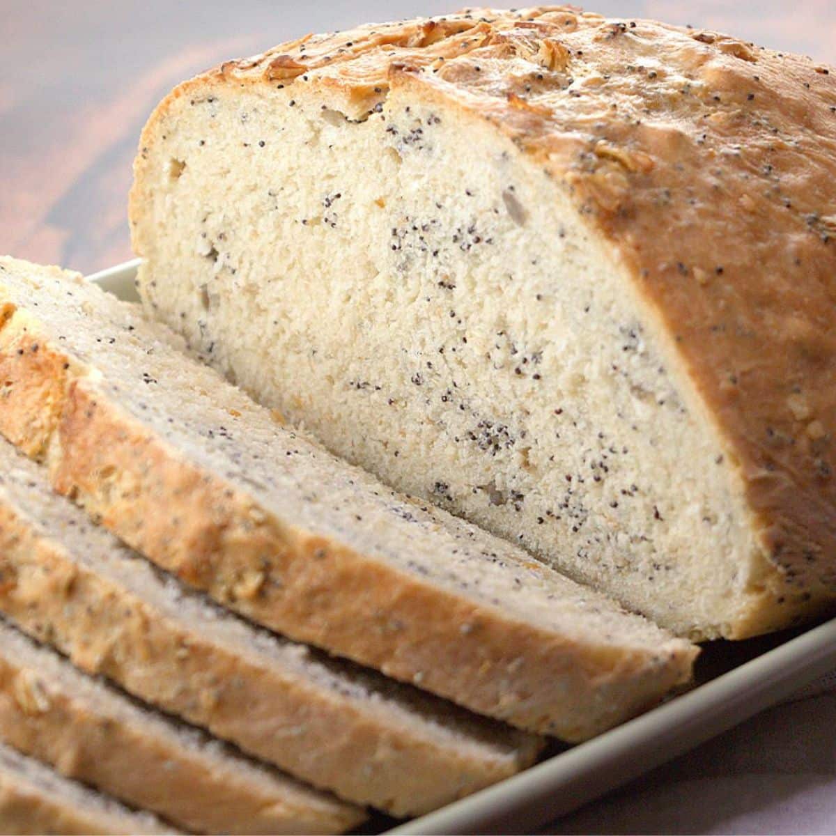 A tableview of a sliced loaf of pumpernickle bread infused with seeds and grains - Hostess At Heart