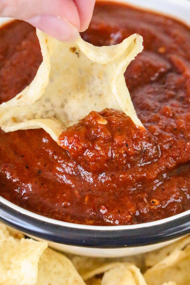 Close up view of a chip scooping a serving of blended salsa roja recipe - Hostess At Heart