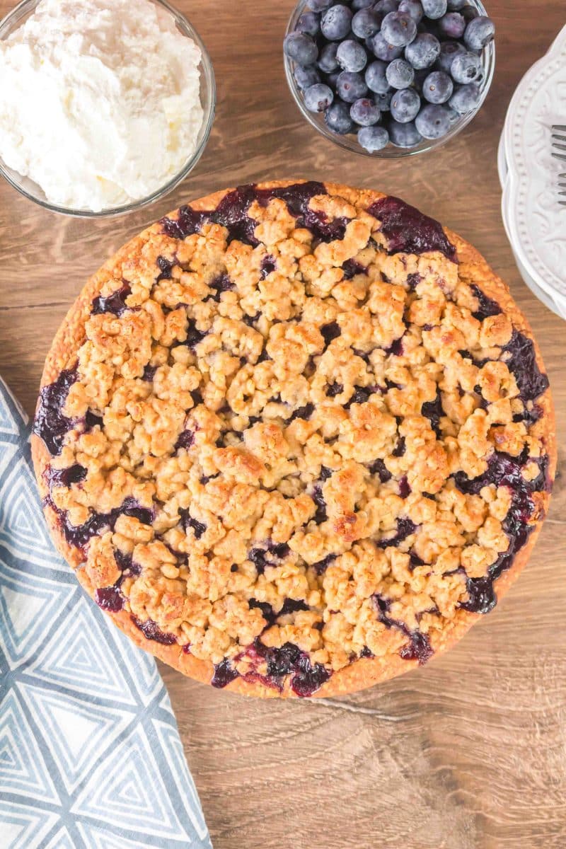 Top down view of a baked blueberry pie topped with golden crumble - Hostess At Heart