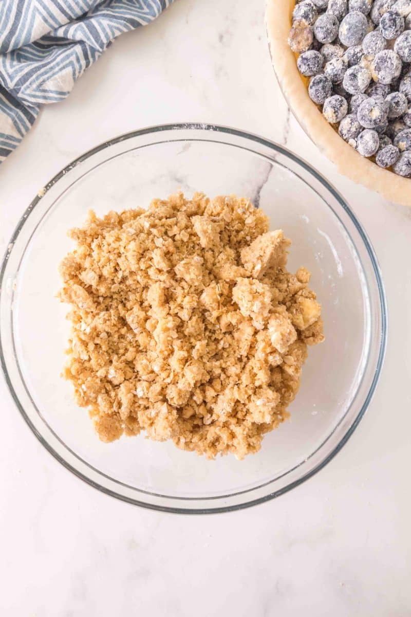 A bowl filled with streusel topping ingredients including oats, butter, flour, and sugar. Hostess At Heart