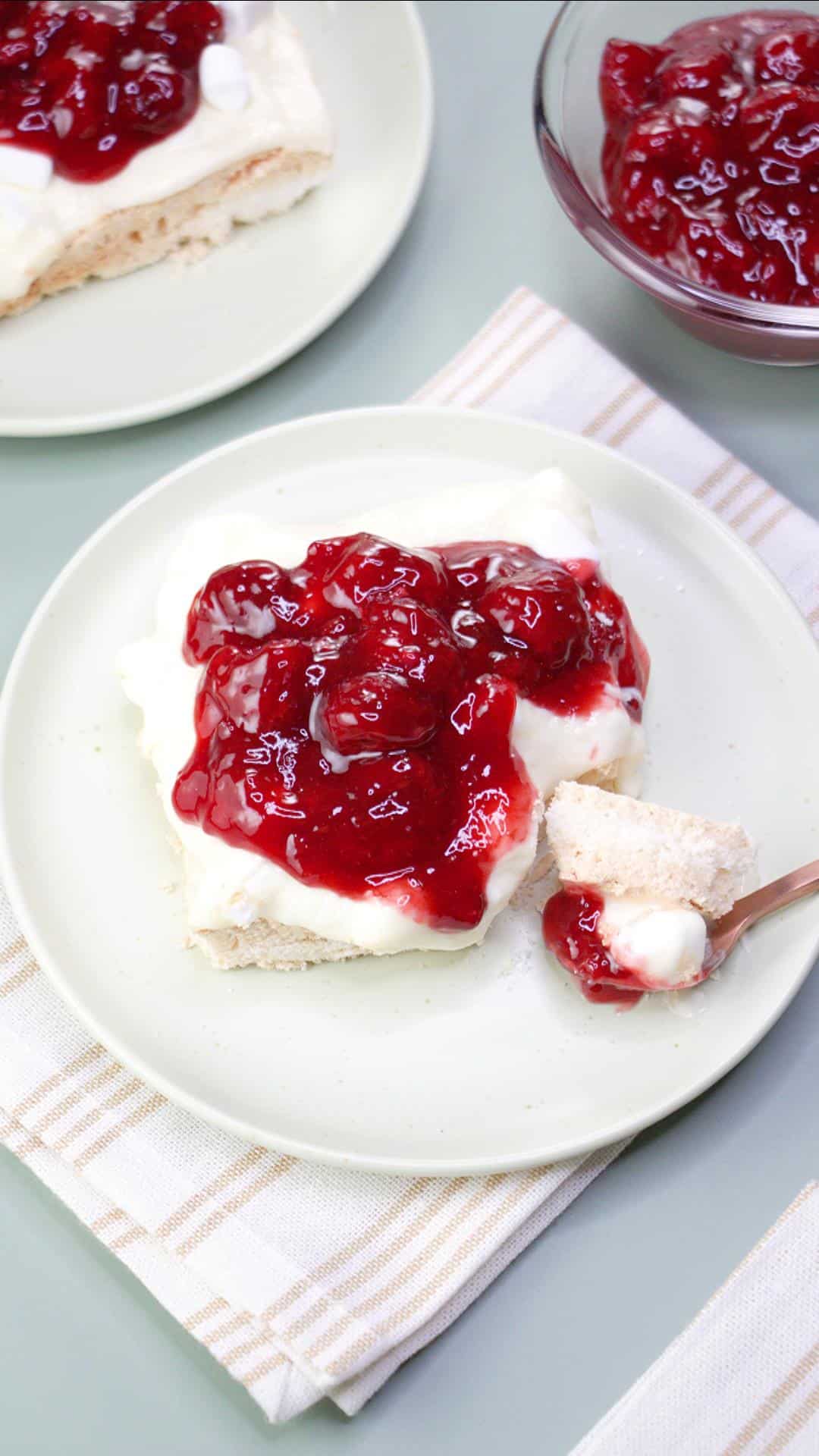 Top down view of a baked meringue bar topped with sweet cream cheese mix and a thick cherry raspberry filling - Hostess At Heart