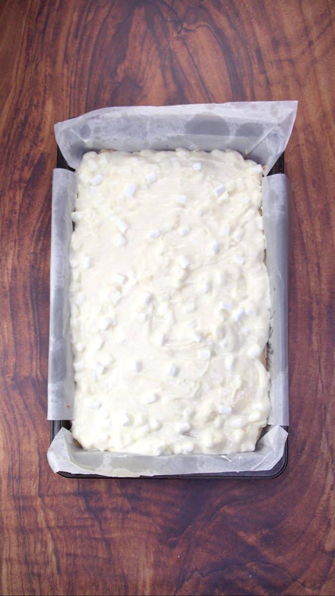 A cream cheese mixture loaded with miniature marshmallows on a pan of baked meringue - Hostess At Heart