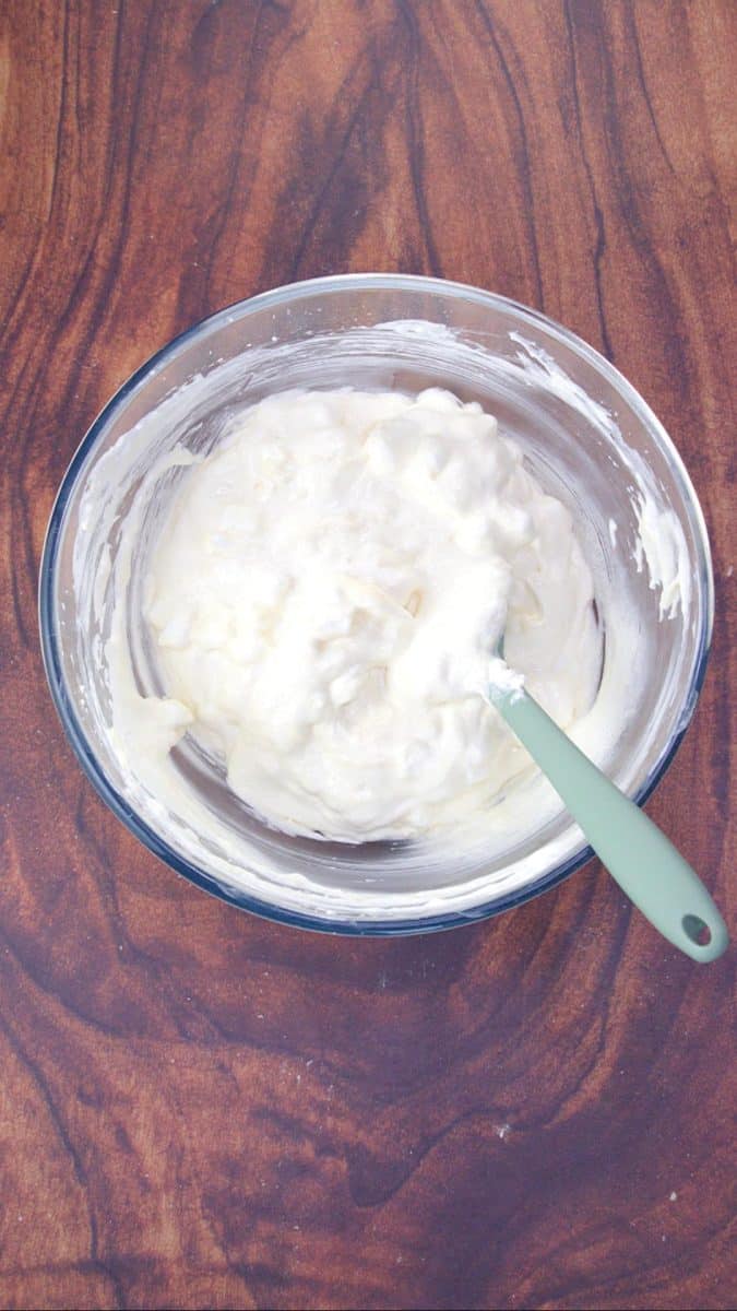A mixing bowl filled with a whipped cream cheese mixture with miniature marshmallows folded into it. Hostess At Heart