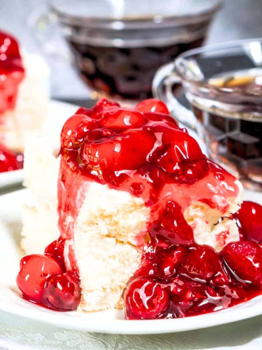 Tableview of soft tender baked meringue topped with a sweet cream cheese layer and a thick cherry raspberry filling - Hostess At Heart