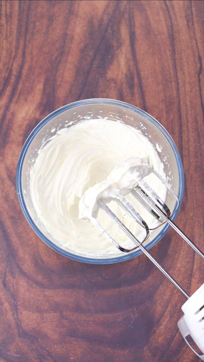 A mixing bowl that's mixed Neufchatel cheese, parmesan cheese, and sour cream together until creamy. Hostess At Heart