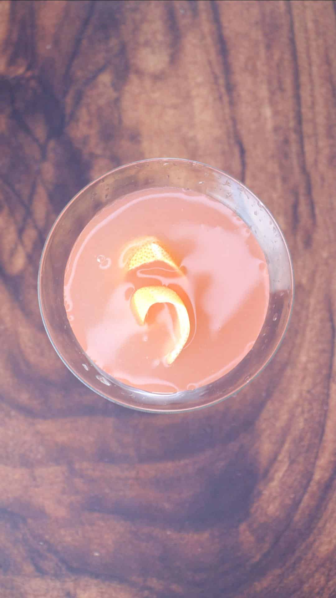 Top down view of a Pink Grapefruit Martini cocktail garnished with grapefruit rind - Hostess At Heart