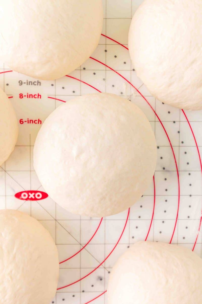 Pieces of bread dough that were shaped into rolls and are now proofed and visually risen - Hostess At Heart