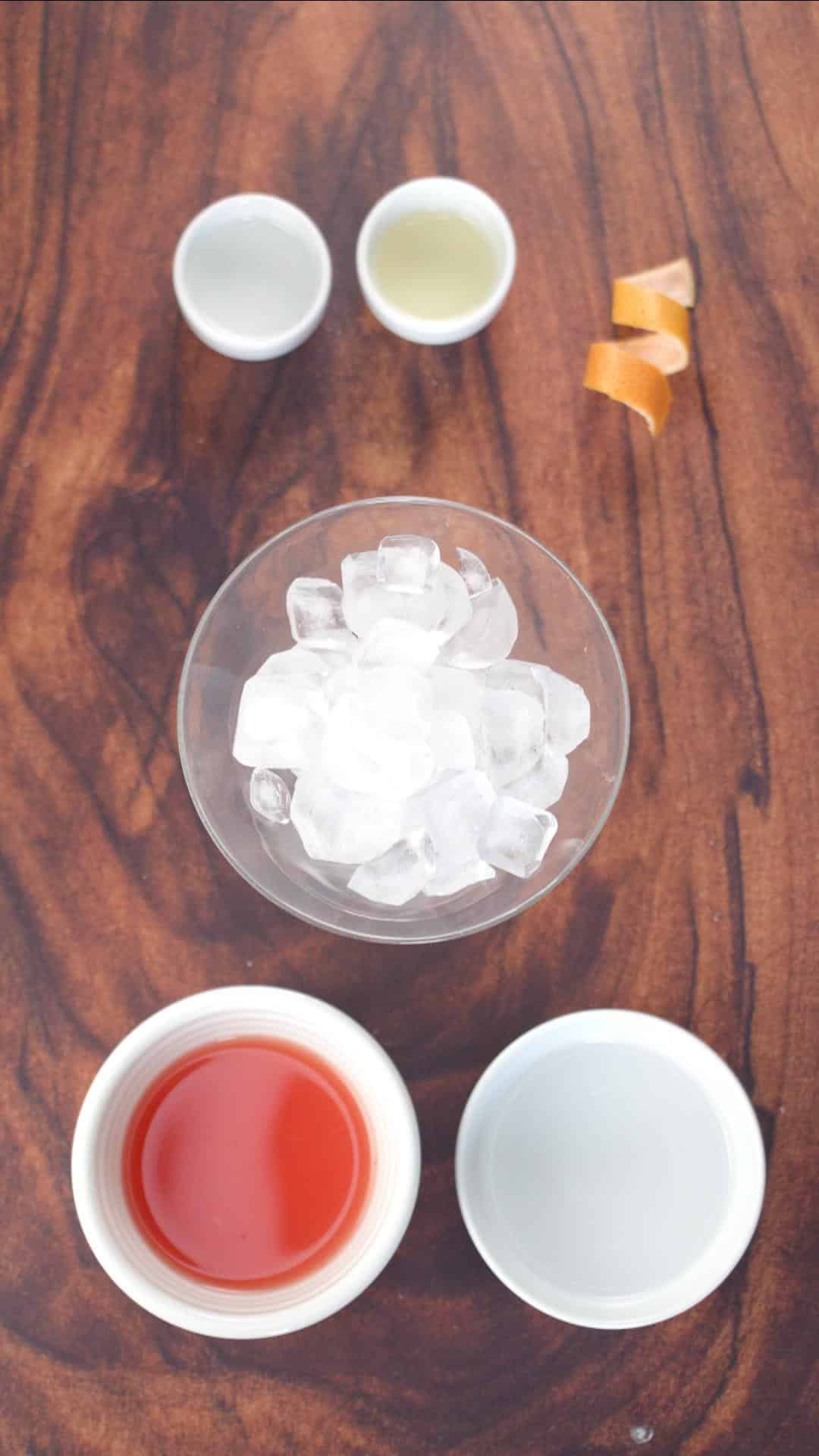 Grapefruit martini ingredients: fresh grapefruit juice, simple syrup, triple sec, ice, and a grapefruit rind curl. Hostess At Heart