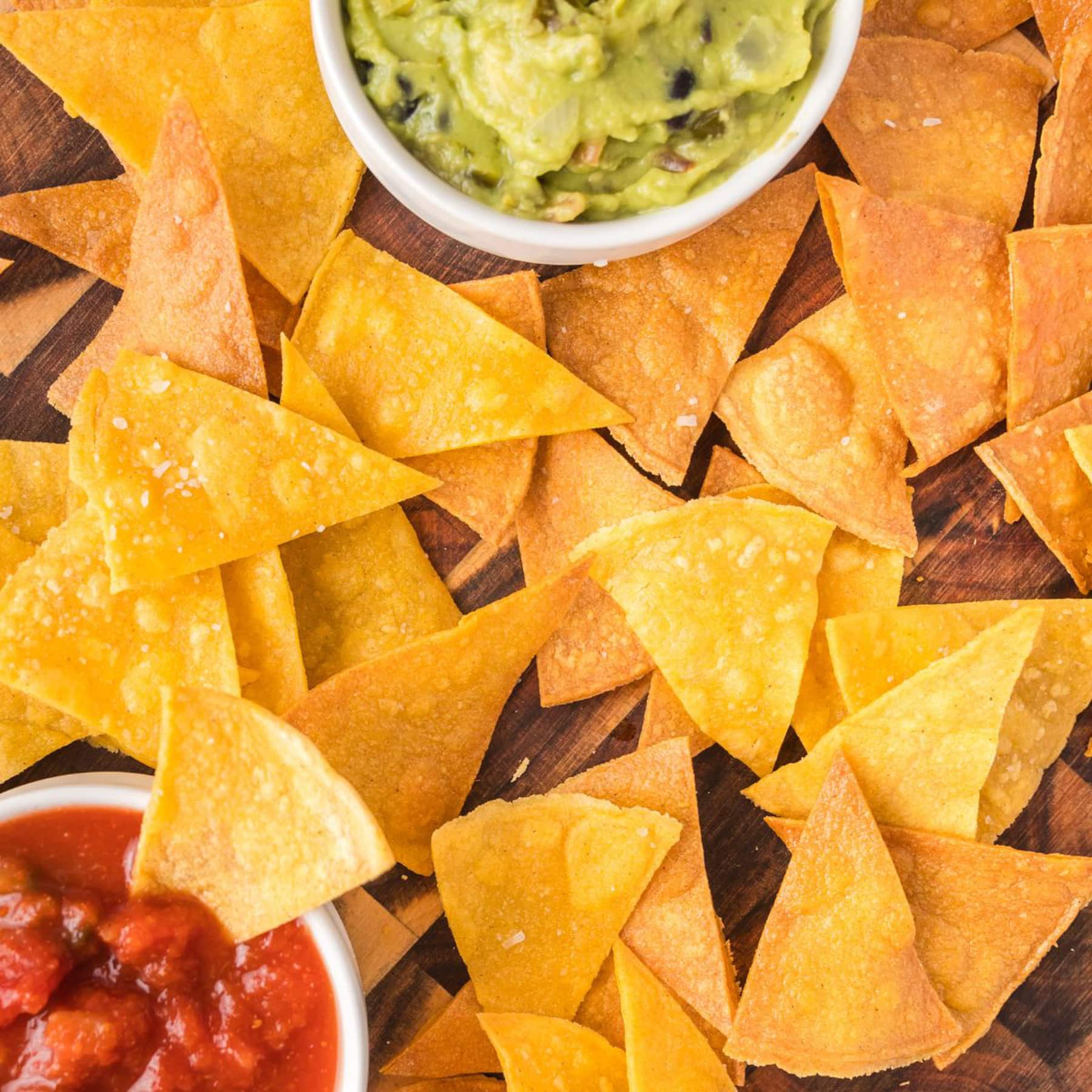 Close up top down view of homemade corn tortilla chip surrounding a bowl of salsa - Hostess At Heart