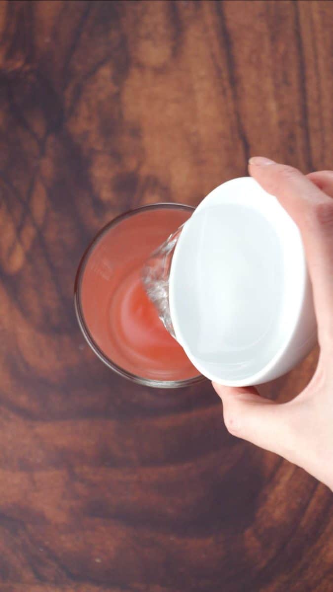 Simple syrup poured over grapefruit juice in a cocktail shaker - Hostess At Heart