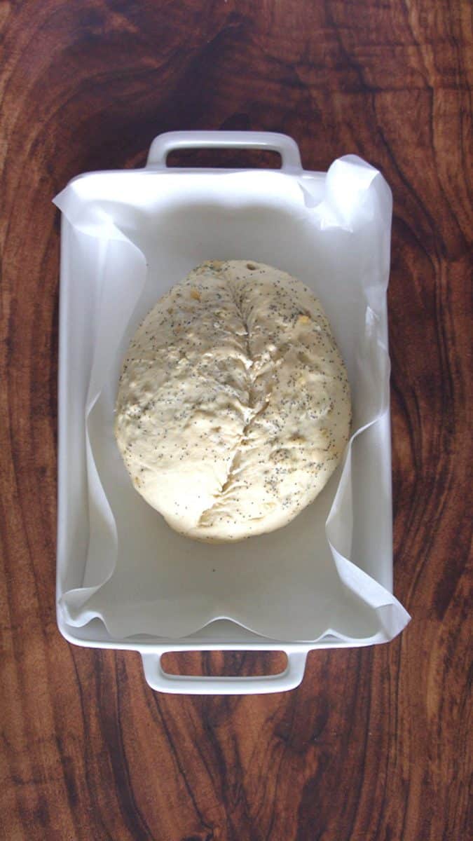 Top down view of unbaked pumpernickel bread loaf that's been scored - Hostess At Heart