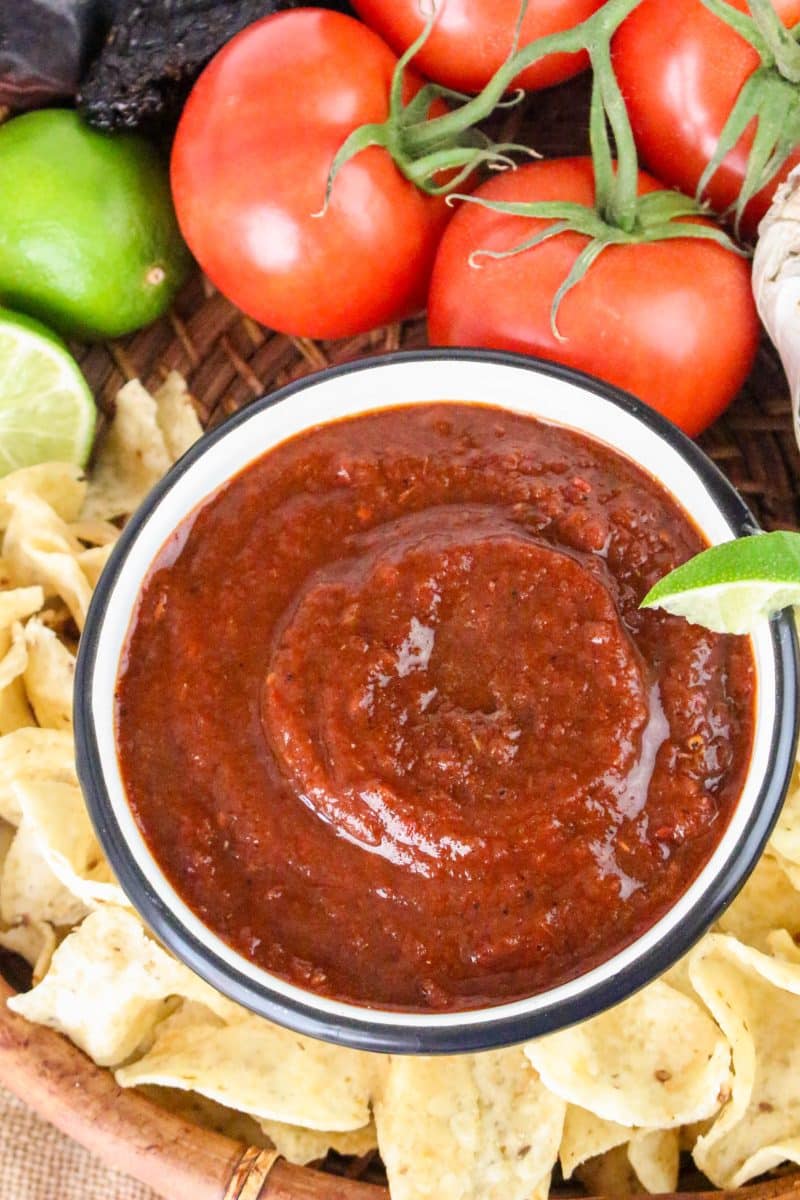Top down view of a bowl of smooth dried chile red salsa surrounded with tortilla chips - Hostess At Heart