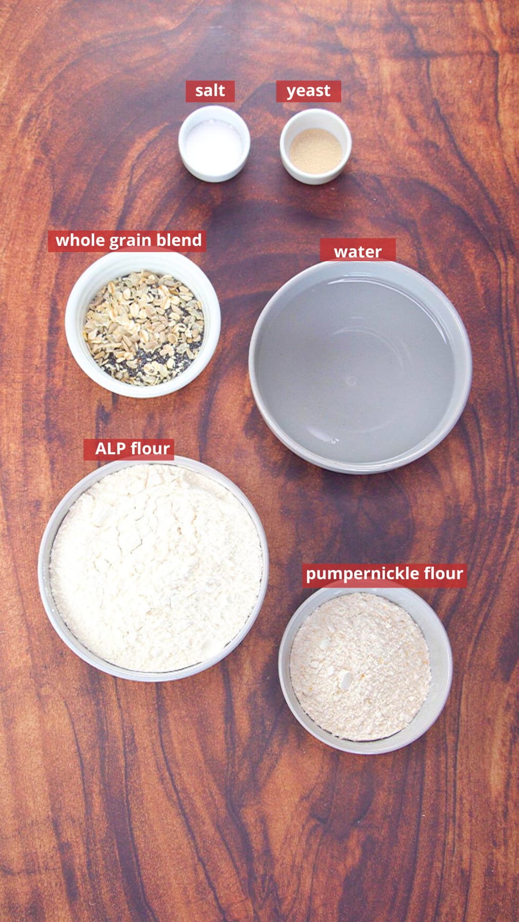 Ingredients used to make pumpernickel bread including bread flour, rye flour, salt, water, yeast, and a whole grain blend. Hostess At Heart