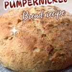 An image for Pinterest of a round loaf of seeded pumpernickel bread - Hostess At Heart