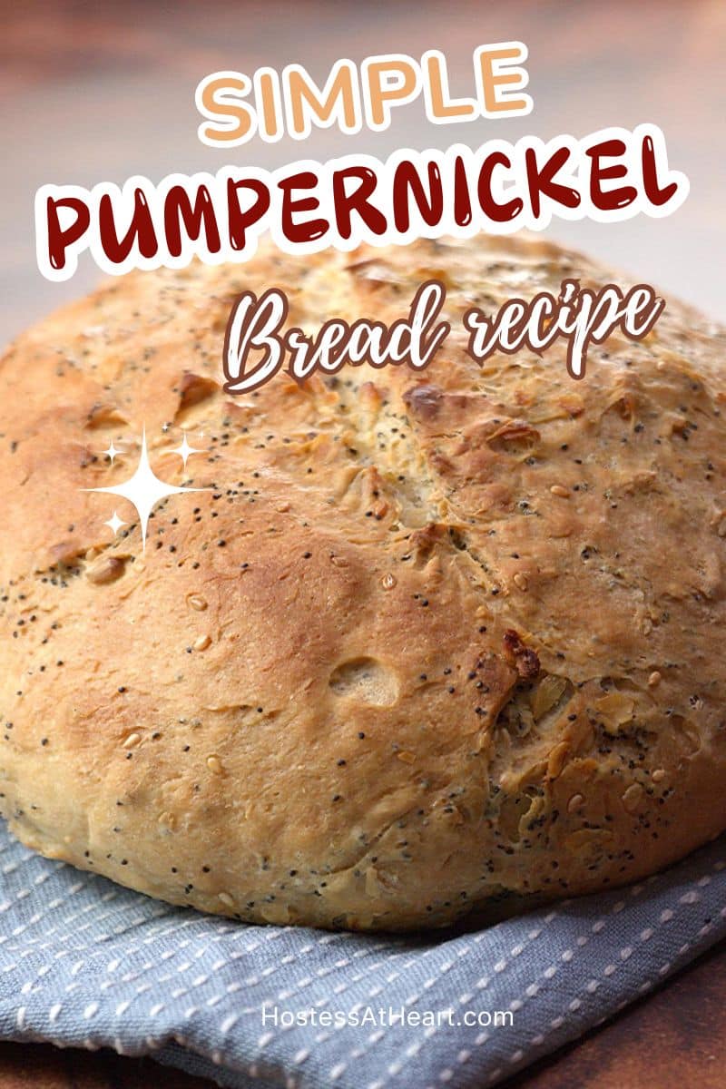An image for Pinterest of a round loaf of seeded pumpernickel bread - Hostess At Heart