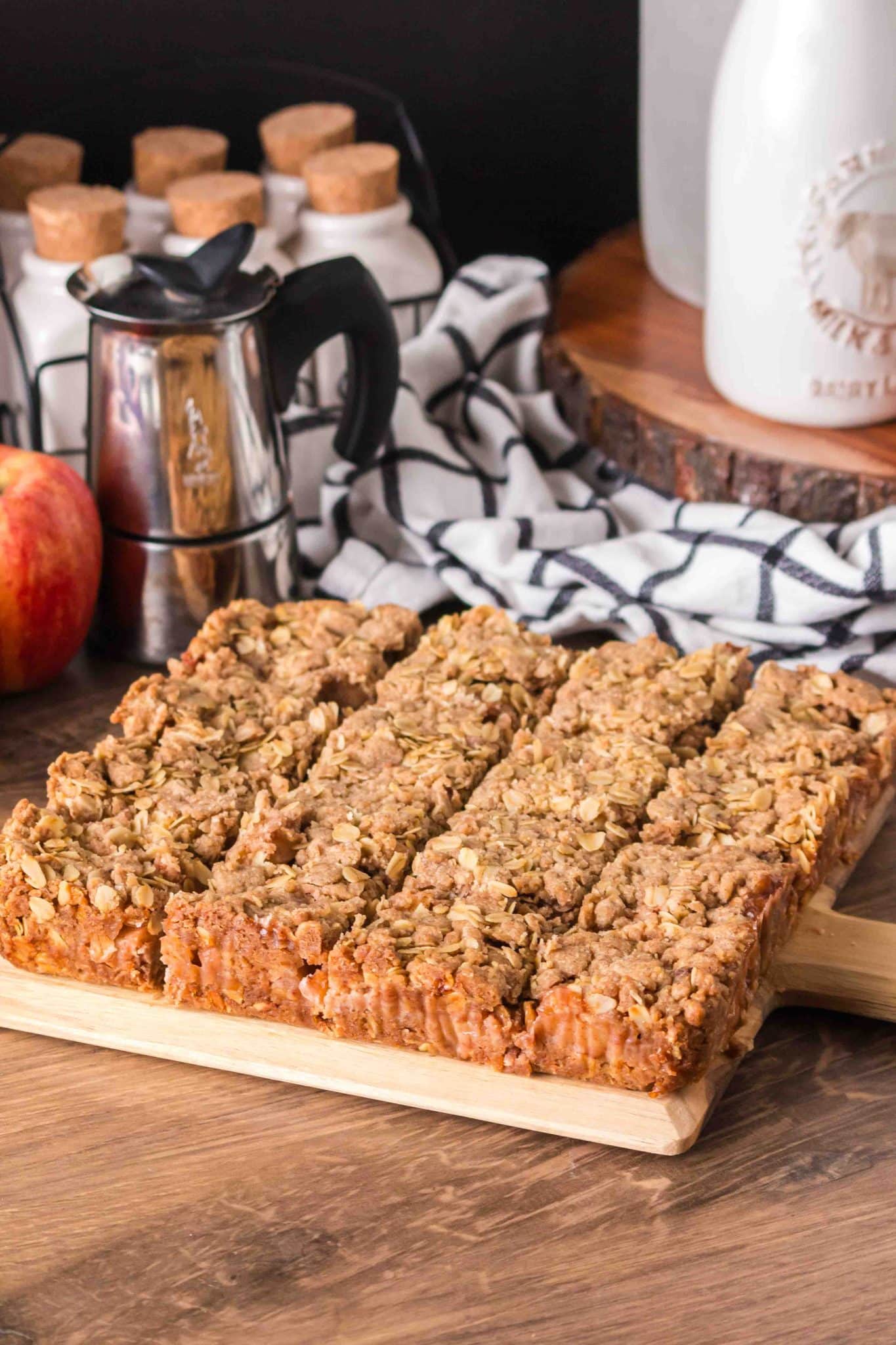 Angled sideview of thick gooey apple crumble bars with oats scored in serving sizes - Hostess At Heart