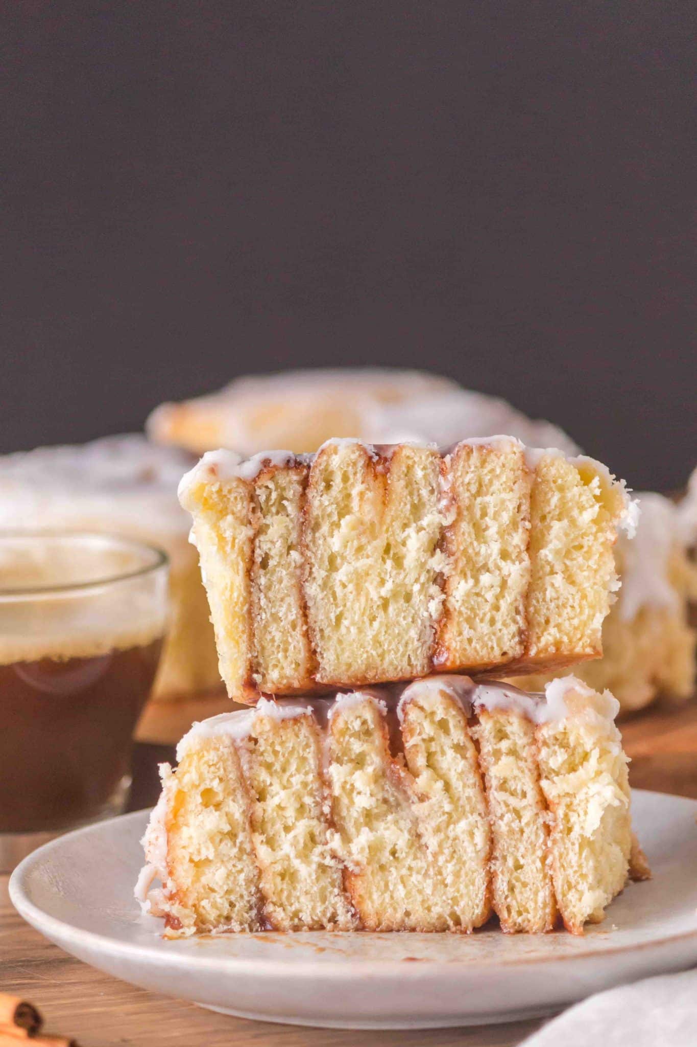 A frosted cinnamon roll that's been cut in half and stacked on to itself - Hostess At Heart