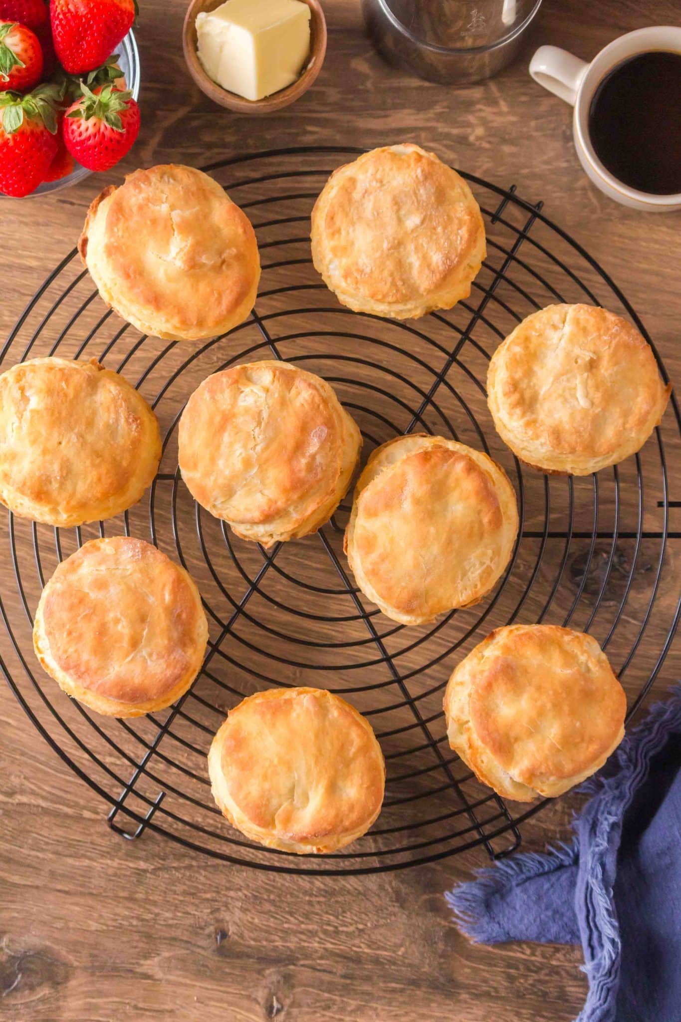 Top down view of baked fluffy biscuits sitting on a cooling rack. Hostess At Heart