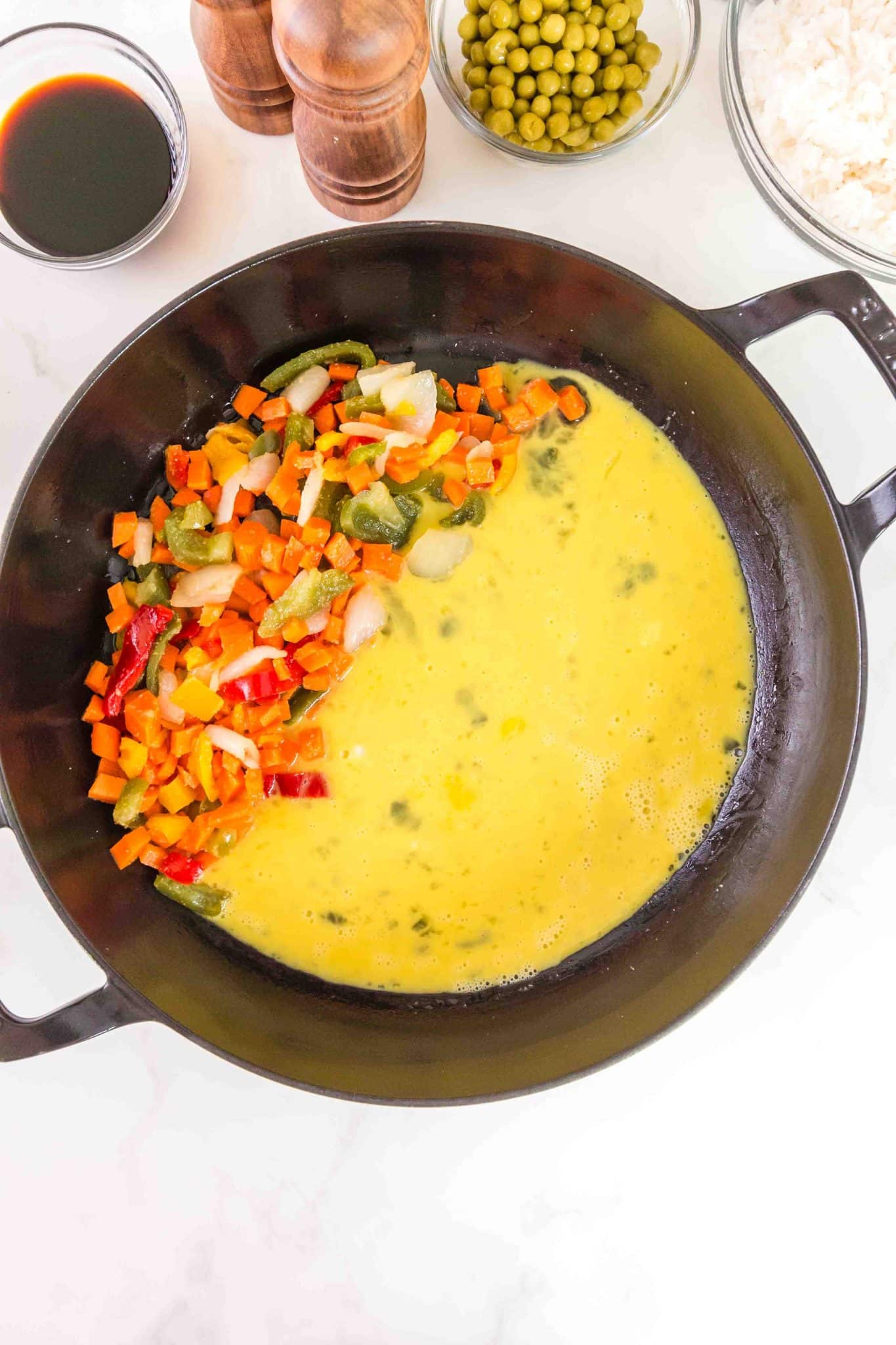 Top down view of egg added to a skillet containing cooked vegetables - Hostess At Heart