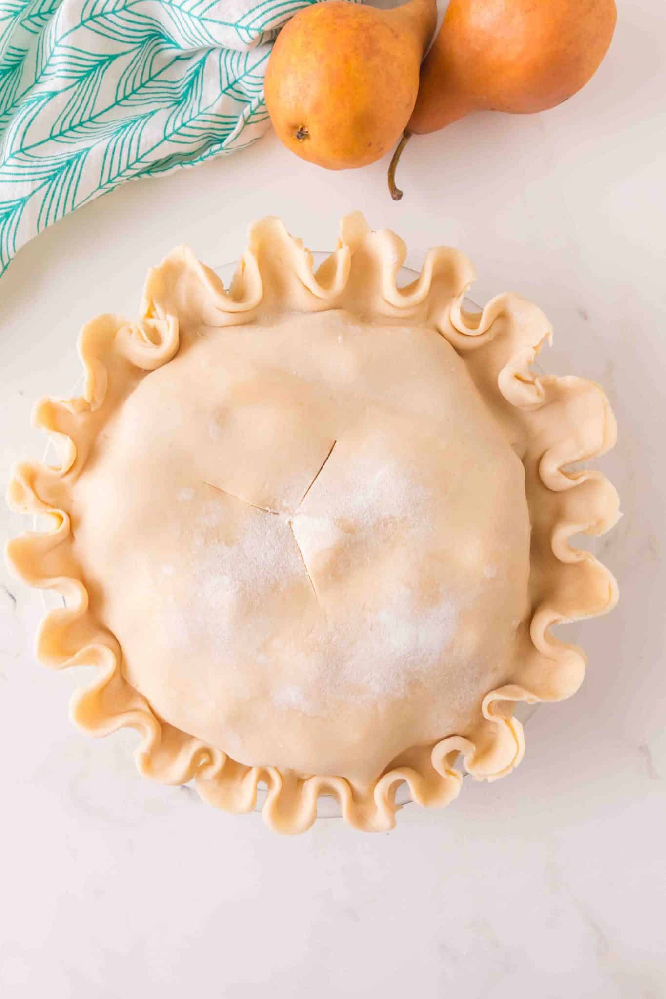 A double crusted pie with fluted edges, dusted with white sugar, and vented with three slits. Hostess At Heart