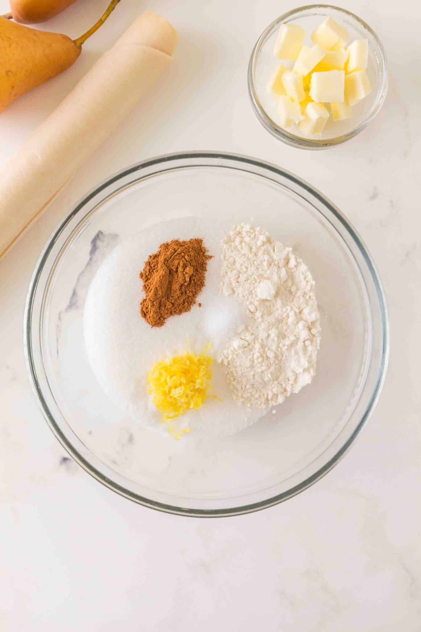 Ingredients combined for pear filling including sugar, flour, cinnamon, and lemon zest - Hostess At Heart