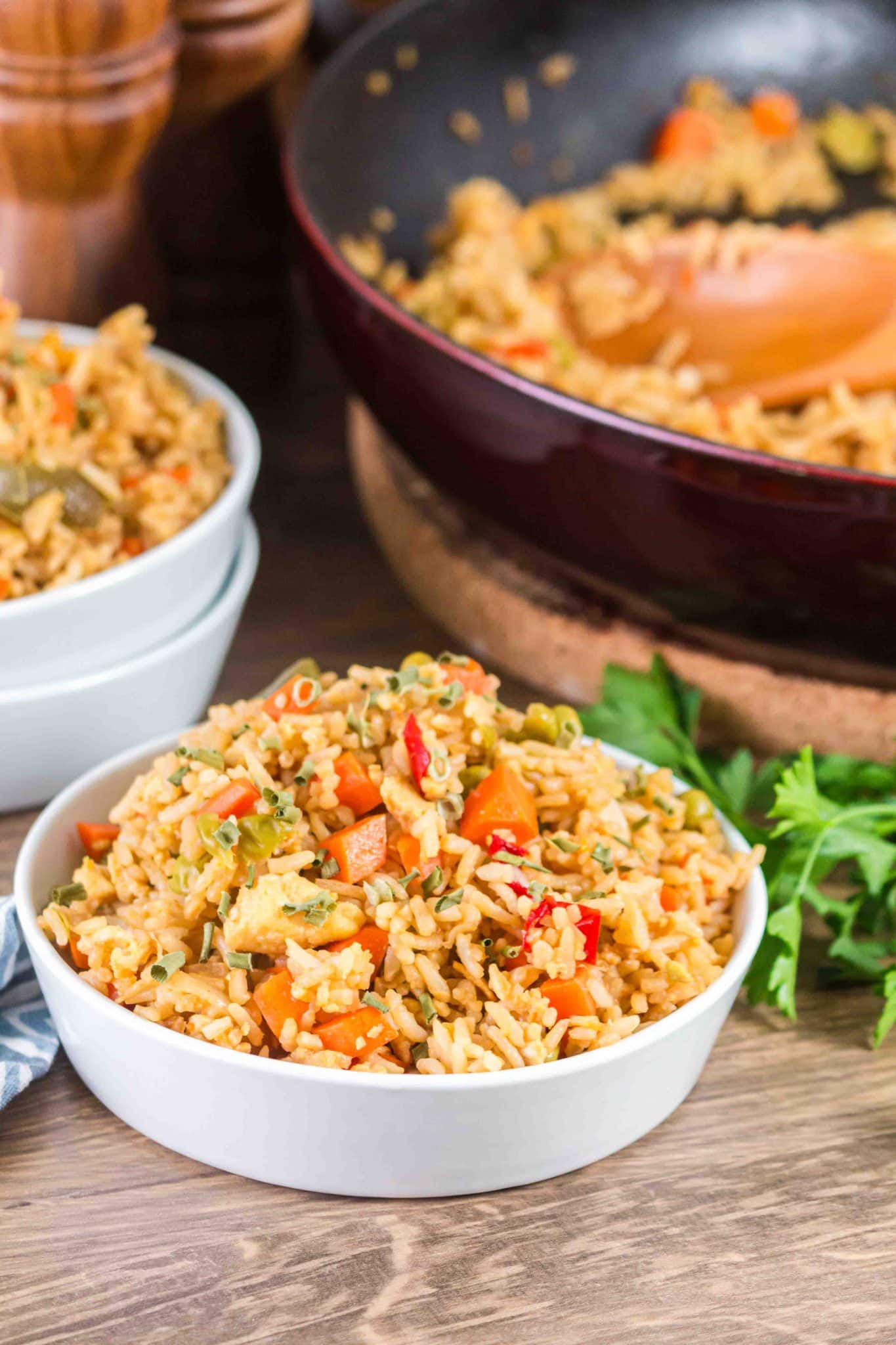 A front view of a bowl filled with vegetarian fried rice that's been garnished with fresh herbs. Hostess At Heart