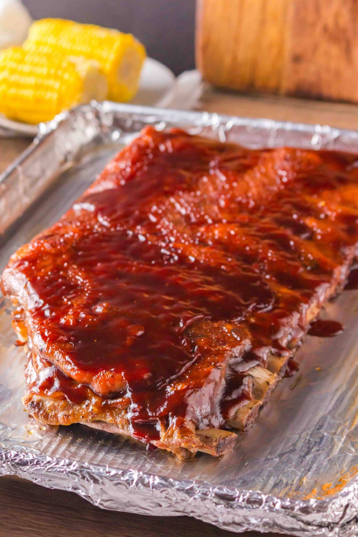Freshly oven baked barbecue ribs resting on a foil-lined baking sheet - Hostess At Heart