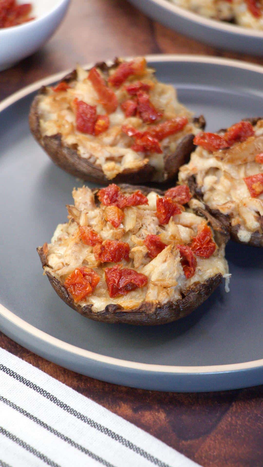 Angled view of a crab stuffed portabella mushroom topped with sun dried tomatoes - Hostess At Heart