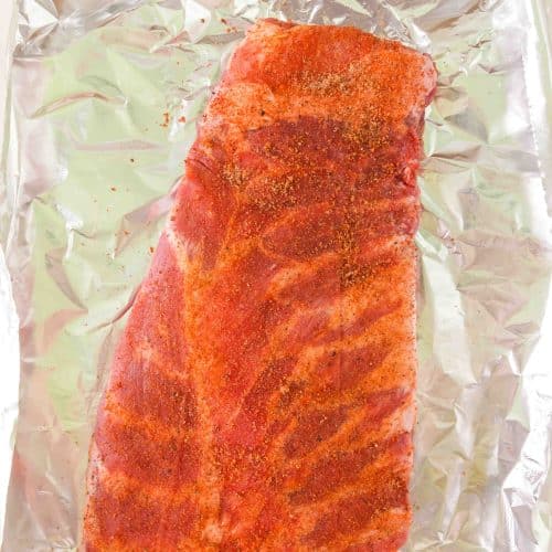 A dry rub applied to a baby back rib rack - Hostess At Heart