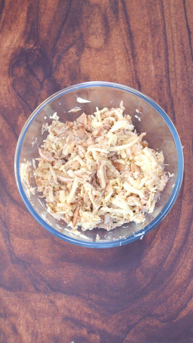 A mixing bowl filled with lump crab, shredded Havarti cheese, and garlic. - Hostess At Heart