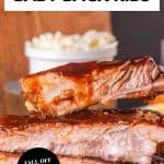An image for Pinterest of a stack of oven baked baby back ribs covered in bbq sauce - Hostess At Heart