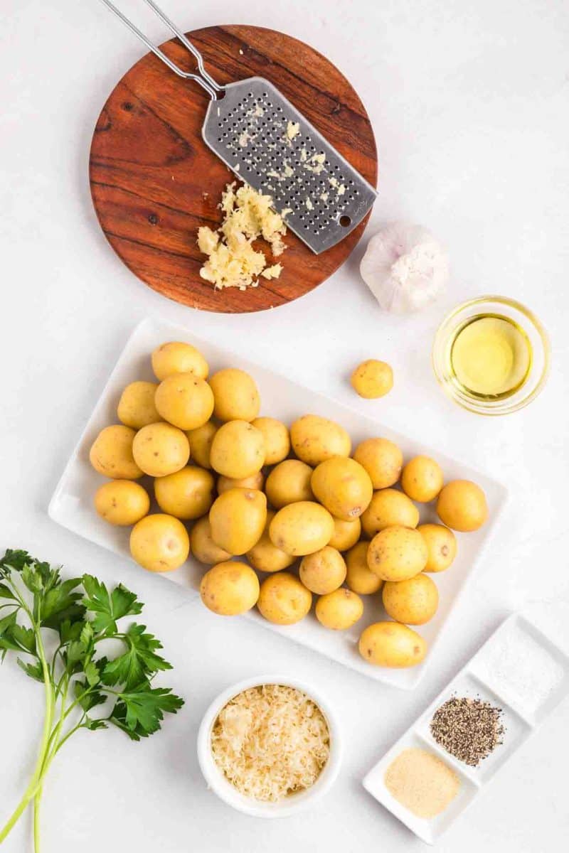Ingredients: baby yellow yukon potatoes, shredded parmesan, parsley, minced garlic, oil, salt, pepper, and garlic powder - Hostess At Heart