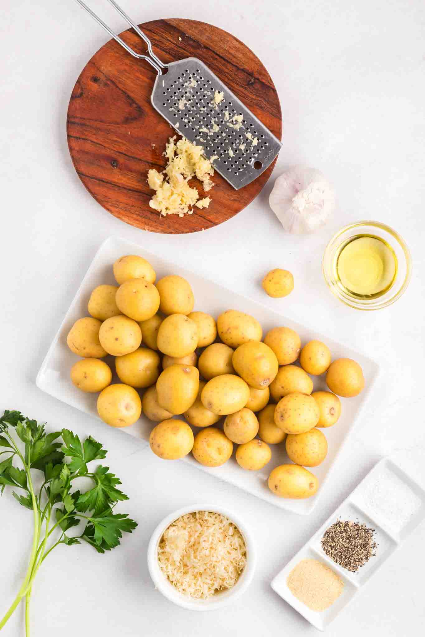 Ingredients: baby yellow yukon potatoes, shredded parmesan, parsley, minced garlic, oil, salt, pepper, and garlic powder - Hostess At Heart