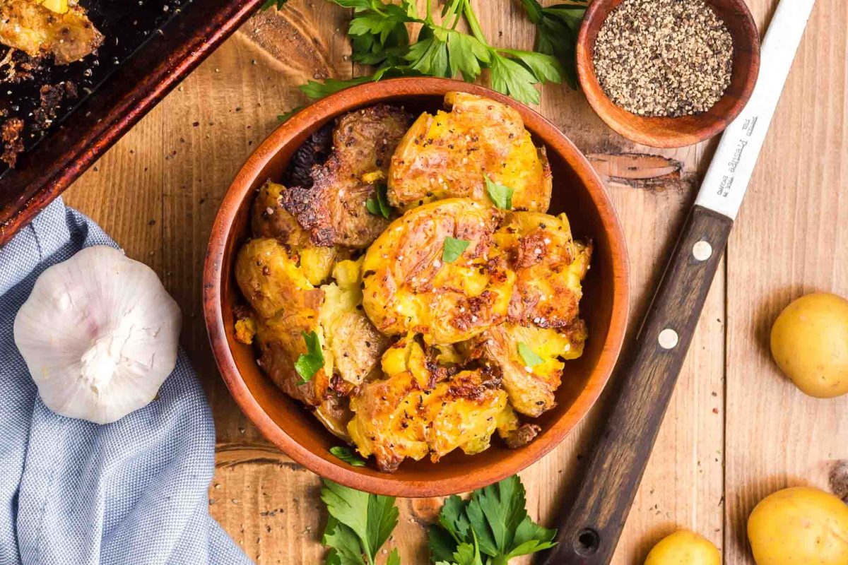 Top down view of a serving dish filled with baked garlic smashed potatoes - Hostess At Heart