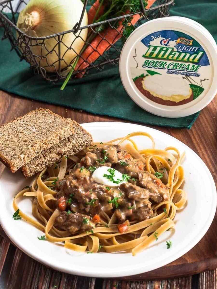 Angled view of a plate of beef stroganoff sauce over whole wheat fettuccine pasta - Hostess At Heart