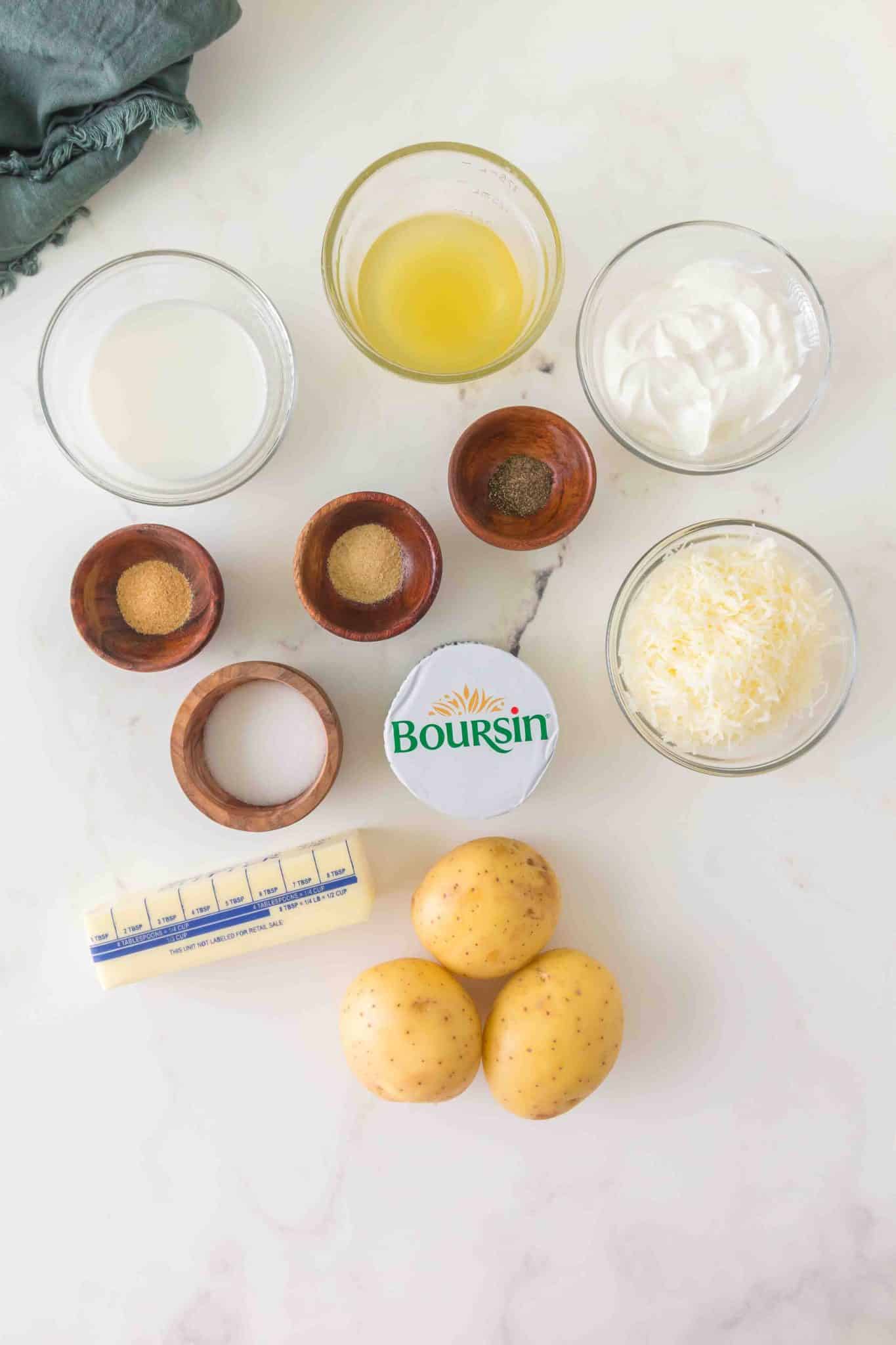 Boursin Cheese Potato casserole recipe ingredients: Yukon potatoes, butter, milk, Boursin cheese, parmesan cheese, garlic powder, onion powder, salt, pepper, and sour cream in individual dishes - Hostess At Heart