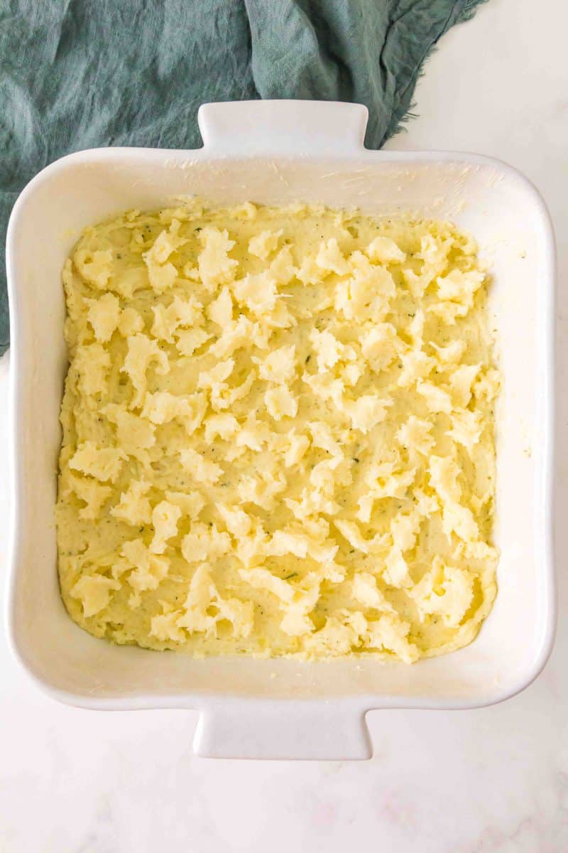 A topping made of grated parmesan cheese and butter spooned over a mashed potato casserole - Hostess At Heart