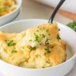 Close up view of a dish holding cheesy boursin mashed potatoes garnished with parsley - Hostess At Heart