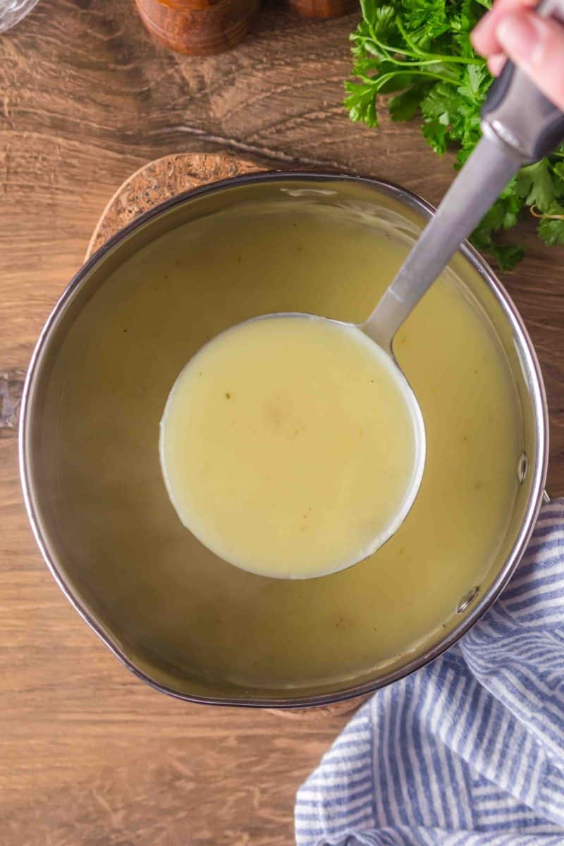A ladle lifting chicken gravy from the pot - Hostess At Heart