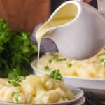 a gravy boat pouring homemade chicken gravy onto mashed potatoes - Hostess At Heart