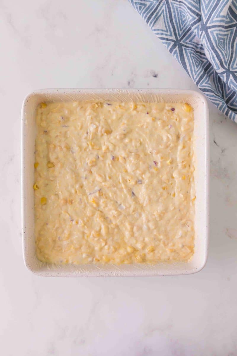 A baking dish filled with mixed corn casserole ingredients - Hostess At Heart